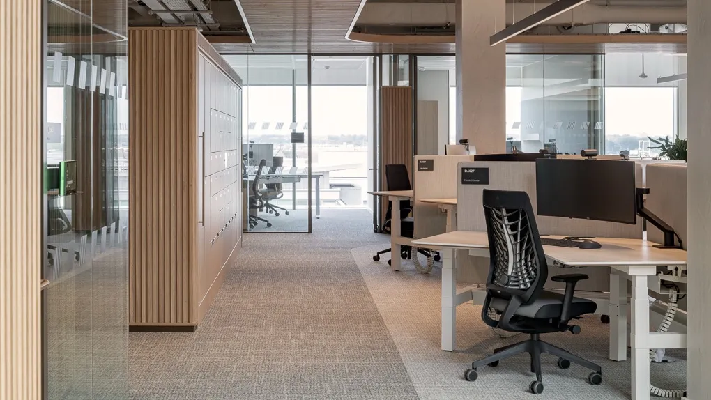 Modern open-plan office with timber finishes and a bank of workplace lockers beside desks